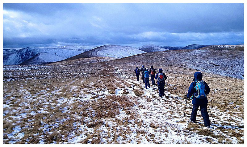 Walkers on a snowy Howgill Fells trail