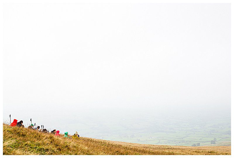 Group of walkers sitting resting in a misty Howgill Fells landscape